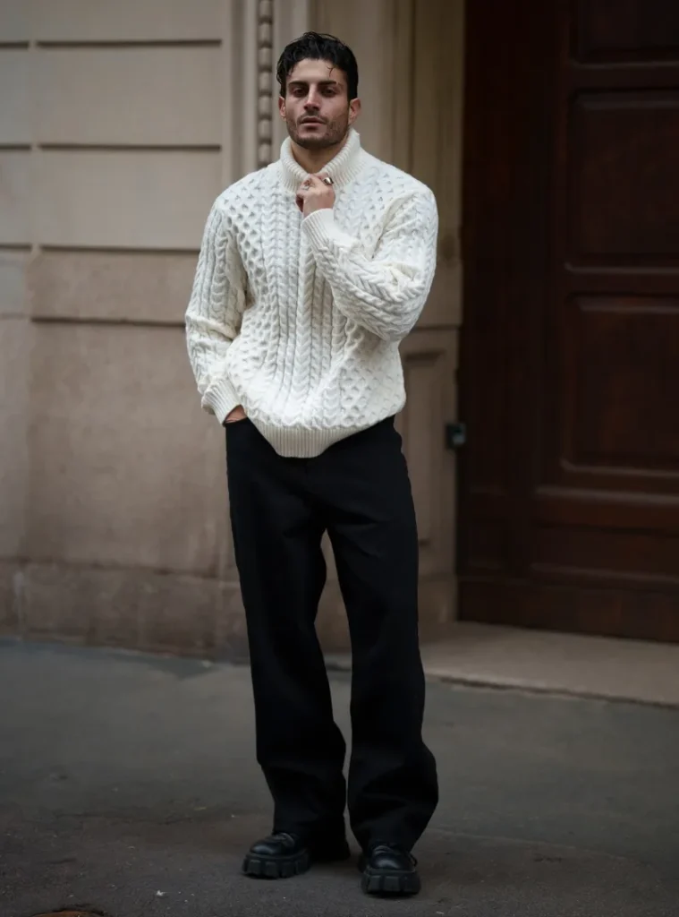 14 Men Casual Winter Outfits Ideas for Everyday Style 4 a guy wearing Chunky Cable Knit with Wide Black Trousers