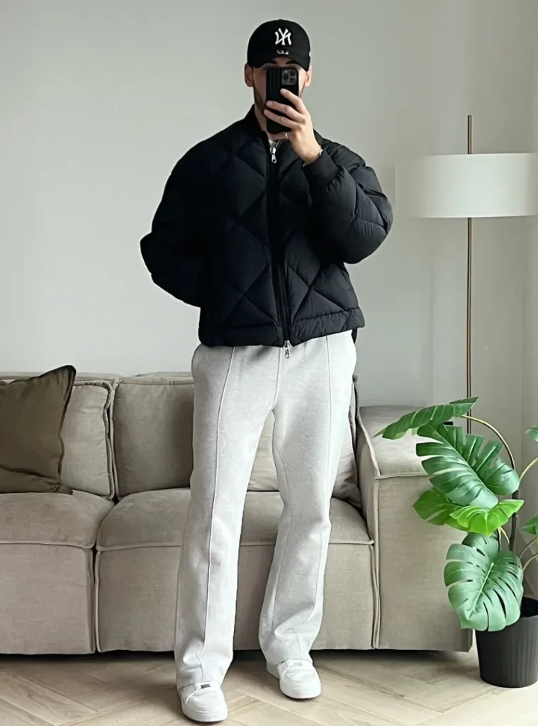 14 Men Casual Winter Outfits Ideas for Everyday Style 3 a man with Black Puffer Jacket With Light Gray Sweatpants