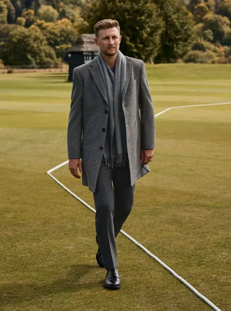 17 Winter Formal Outfits for Men That Look Sharp 6 a man wearing a Tonal Grey Overcoat with Scarf and Tailored Trousers