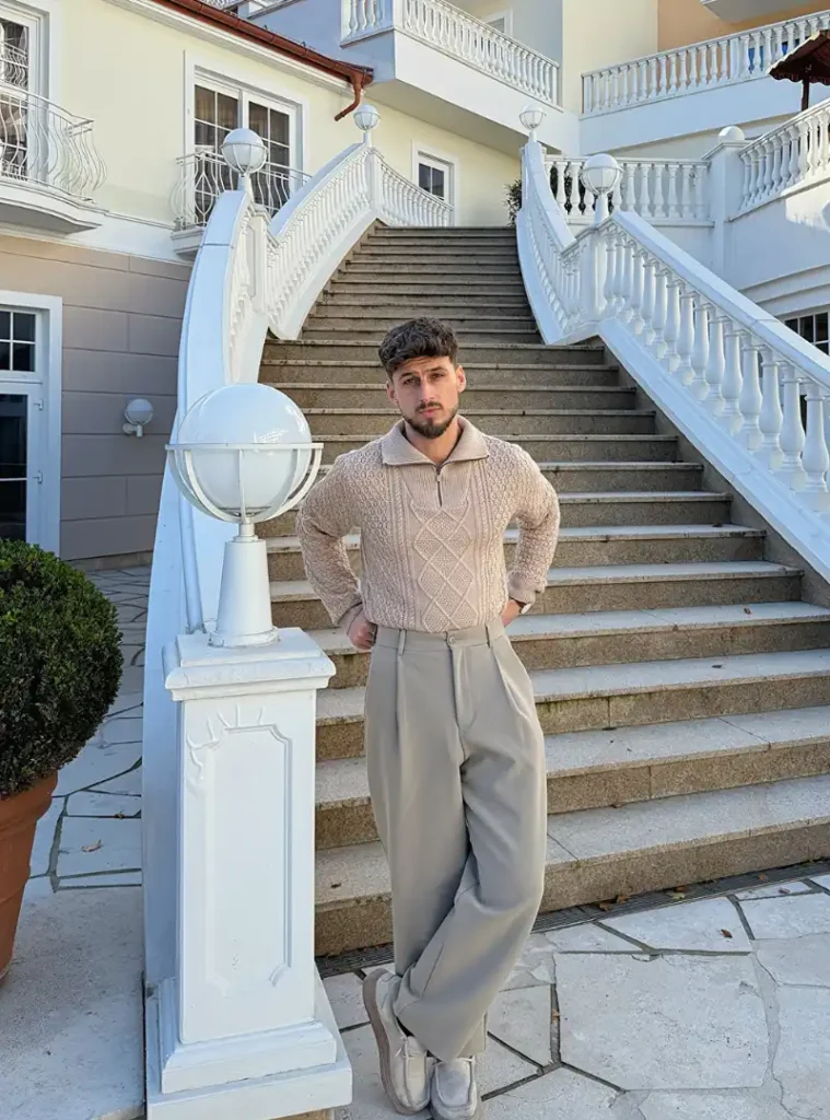 14 Men Casual Winter Outfits Ideas for Everyday Style 6 A man wearing Tucked Quarter-Zip Knit with Pleated Neutral Slacks