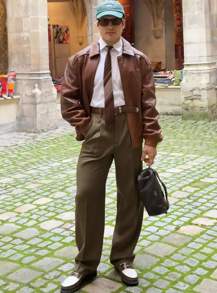 22 Fall Jackets Outfit Ideas for Men to Layer Up in Style 8 a man posing in a Vintage Brown Leather Bomber with Flared Olive Slacks