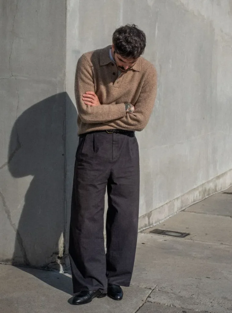 17 Easy Men Fall Outfit Ideas That Keep You Warm 12 a man posing with a Collared Polo Knit Tucked into Wide Charcoal Trousers