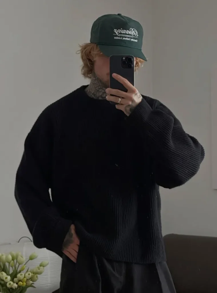 20 Easy Ideas for Fall Casual Outfits Men Can Rely On 15 a man waring a Chunky Black Ribbed Sweater with a Green Cap