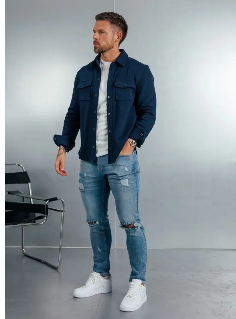 16 Fall Outfits With Jeans for Men You Can Actually Wear 11 a man in a Navy Overshirt with Distressed Light-Wash Jeans
