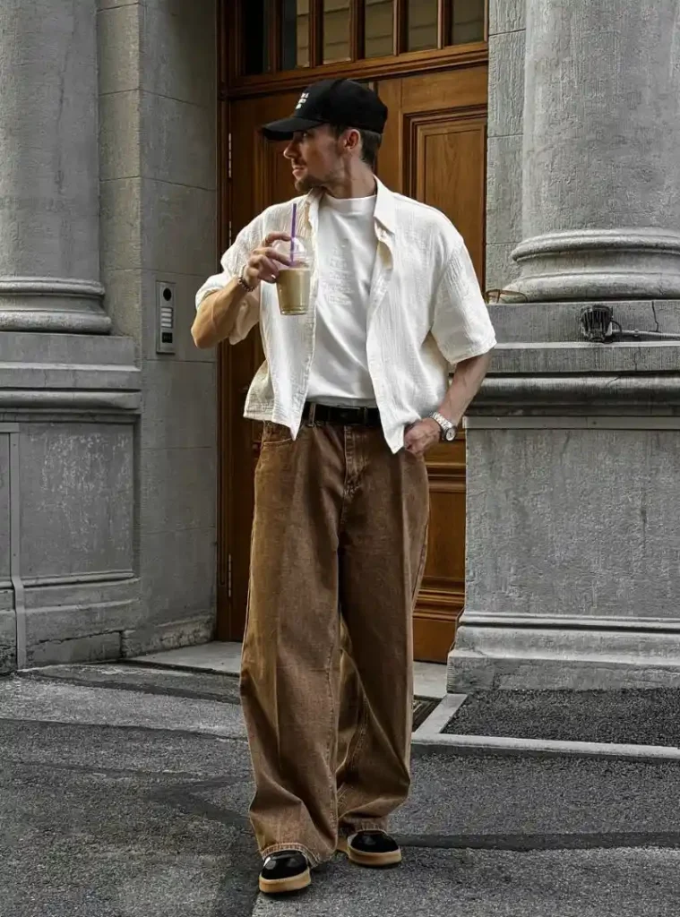 17 Easy Men Fall Outfit Ideas That Keep You Warm 4 a man posing in a Boxy Linen Camp Shirt over Baggy Brown Wash Jeans